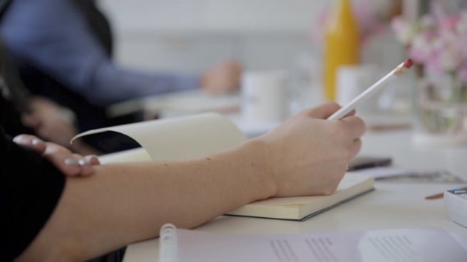 Womans hand writing in a journal | Kelly Chandler Consulting