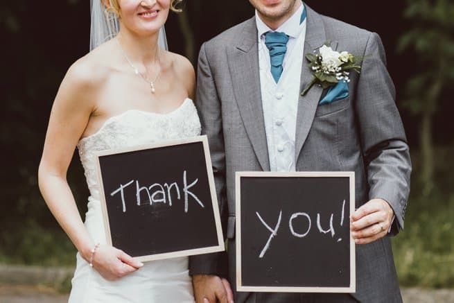 Bride and groom holding thank you chalk board signs | Kelly Chandler Consulting