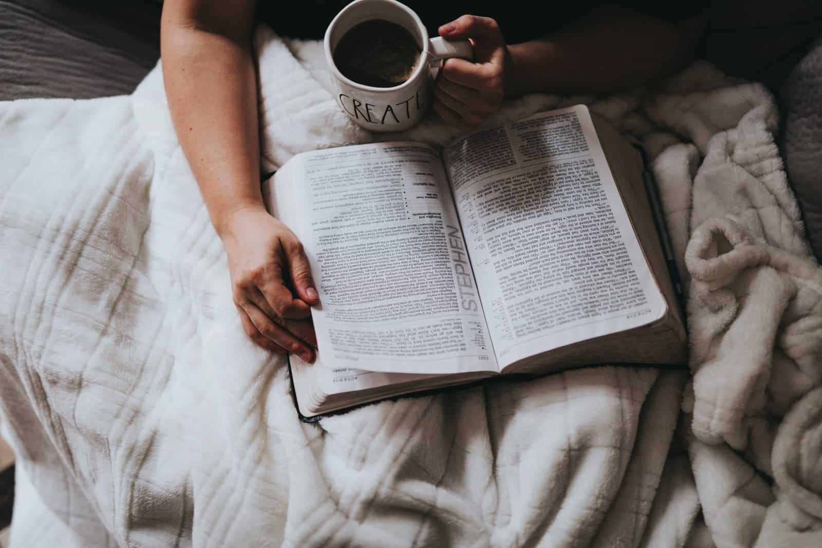 Reading a book in bed with coffee