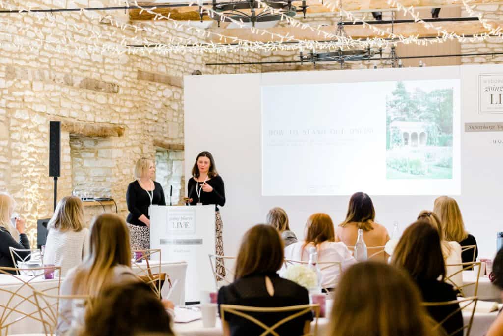 To female guest speakers standing behind a podium