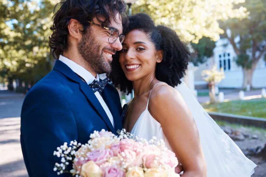 Mixed race bride and groom smiling

