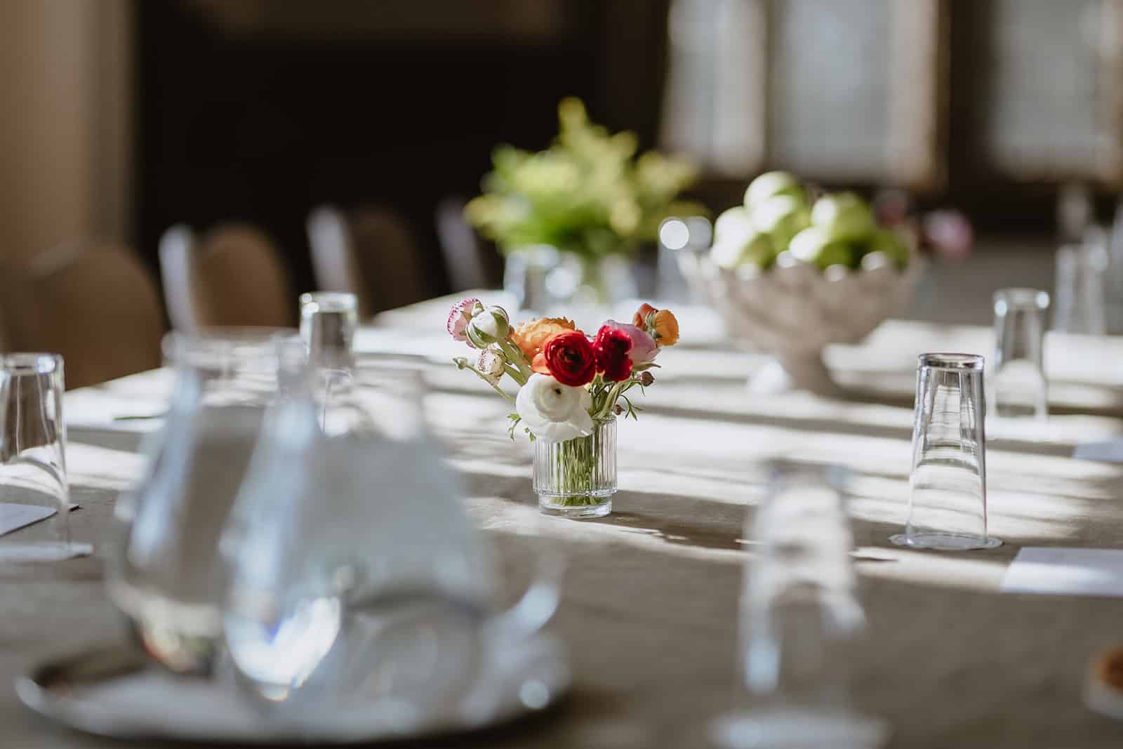 Elegant dining table set with flowers and glassware for a formal event.