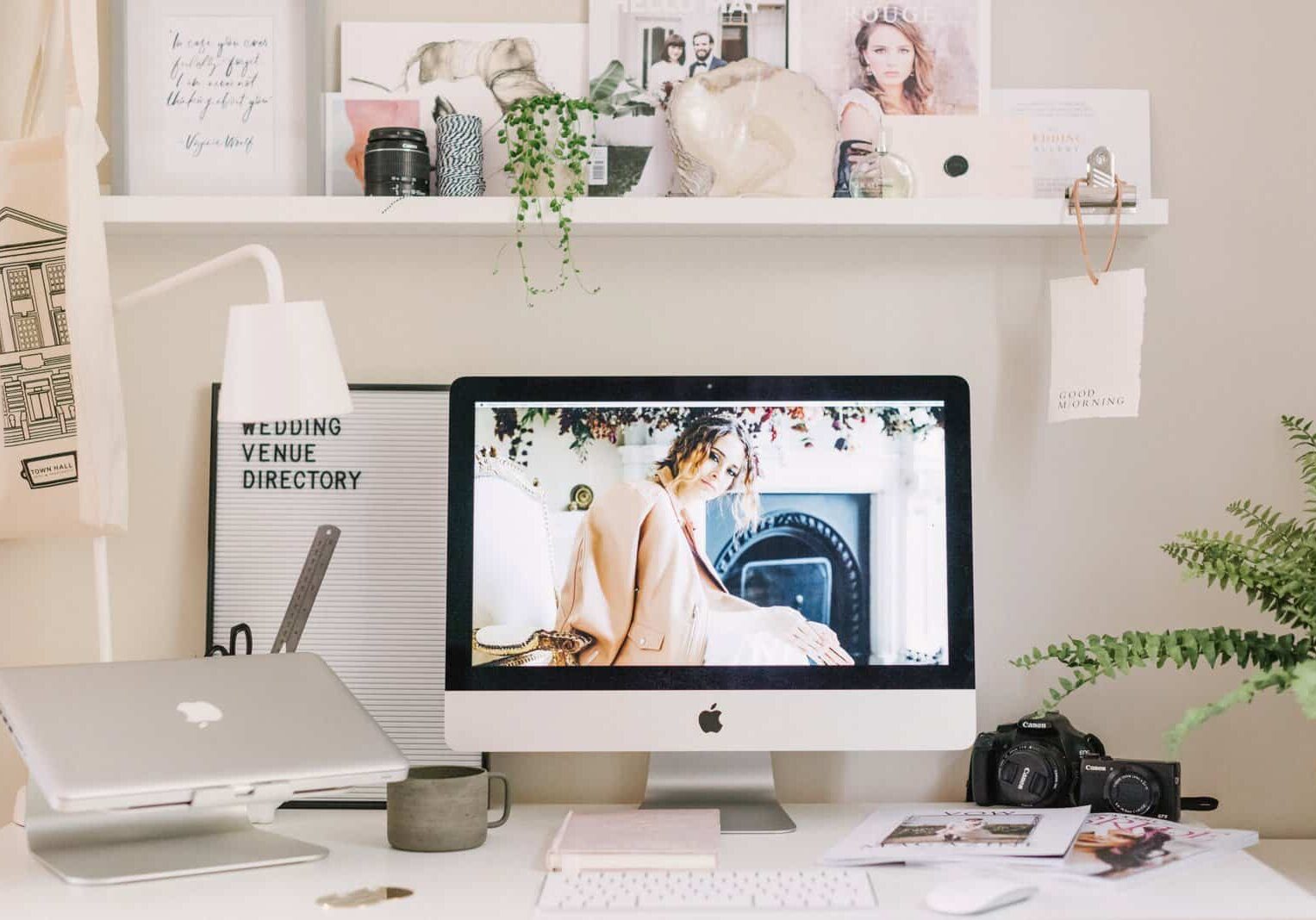 Styled work desk with apple mac plants and photo frames