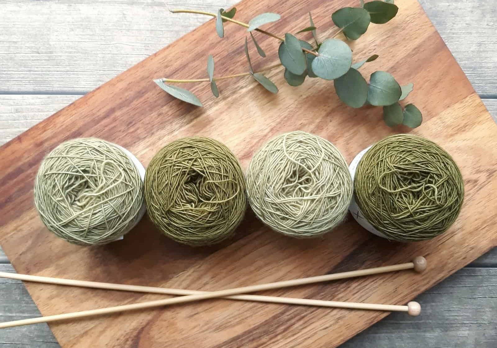 Four green balls of wool