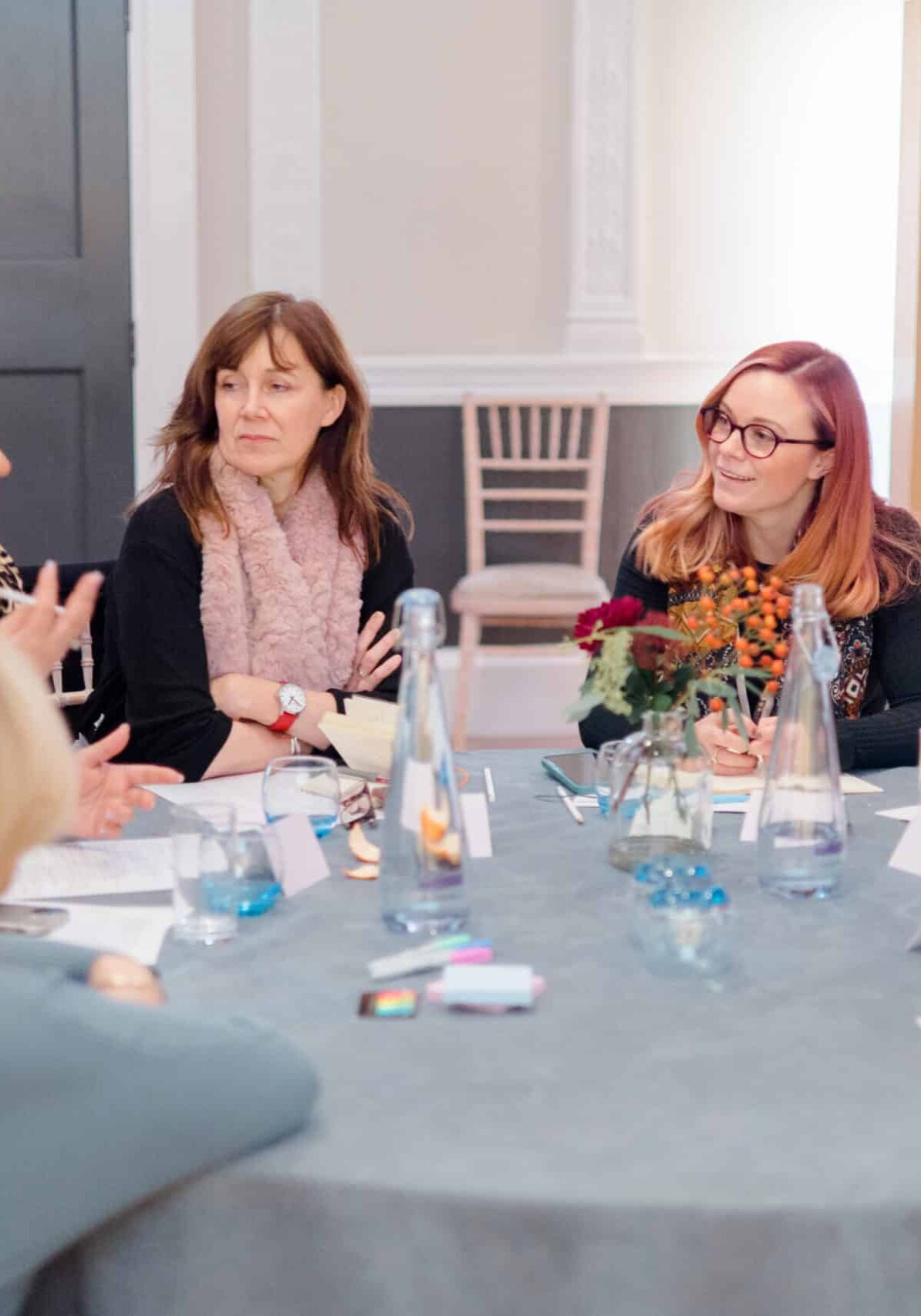 Group of women in a business meeting around a table in a conference room.