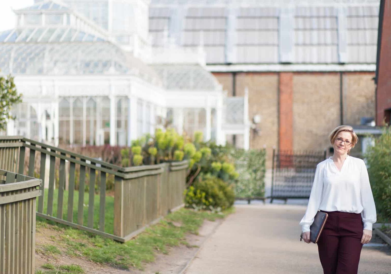 Lady standing outside a wedding venue holding a laptop